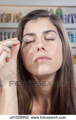 Woman putting on her eyes make up View Large Photo Image Stock Image - Woman putting on her eyes make up. Fotosearch