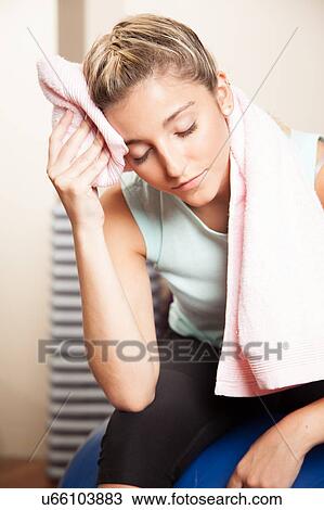 Stock Image - Woman resting after to yoga class. Fotosearch