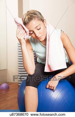Stock Image - Woman resting after to yoga class. Fotosearch