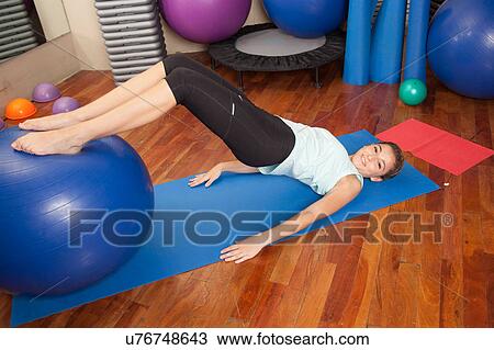 Woman stretching with a ball View Large Photo Image Stock Image - Woman stretching with a ball. Fotosearch
