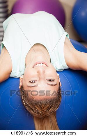 Woman stretching with a ball View Large Photo Image Stock Photograph - Woman stretching with a ball. Fotosearch