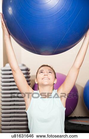 Stock Photograph - Woman stretching with a ball. Fotosearch