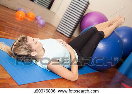 Stock Photograph - Woman stretching with a ball. Fotosearch