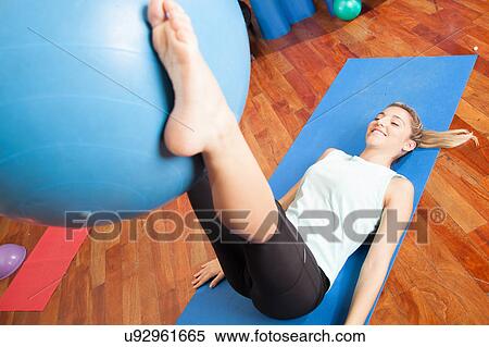 Stock Photography - Woman stretching with a ball. Fotosearch