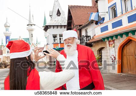 Woman taking a photo to santa claus View Large Photo Image Stock Photo - Woman taking a photo to santa claus. Fotosearch