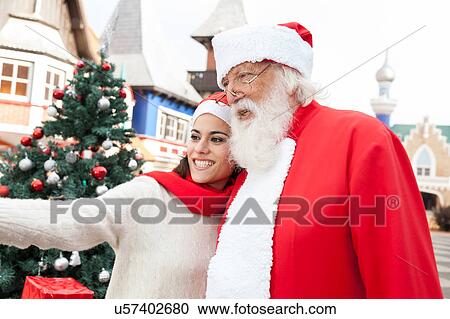 woman taking a selfie with santa claus View Large Photo Image Stock Image - woman taking a selfie with santa claus. Fotosearch