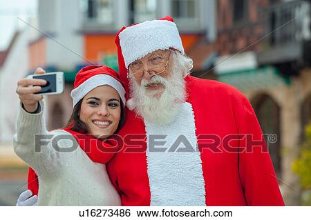 woman taking a selfie with santa View Large Photo Image Stock Photograph - woman taking a selfie with santa. Fotosearch