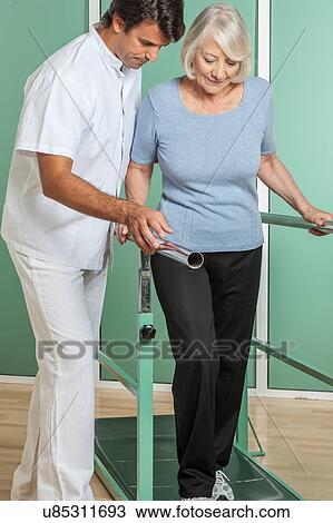 Stock Image - women rehabilitating her legs with his doctor. Fotosearch