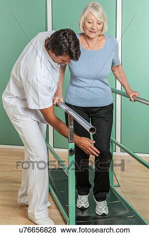 Stock Photo - women rehabilitating her legs with his doctor. Fotosearch