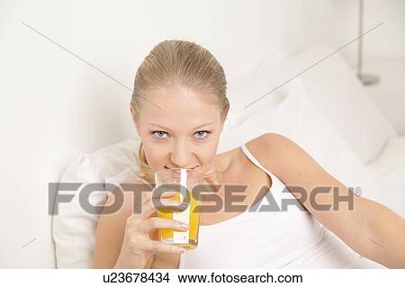 Picture - Young woman drinking a juice. Fotosearch