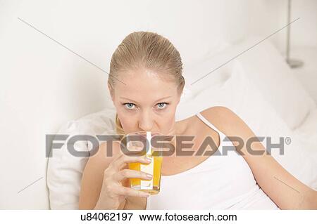 Young woman drinking a juice View Large Photo Image Stock Photo - Young woman drinking a juice. Fotosearch