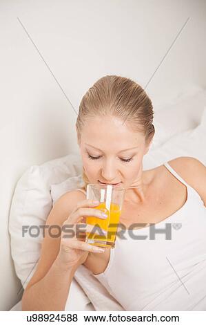 Young woman drinking a juice View Large Photo Image Stock Photo - Young woman drinking a juice. Fotosearch