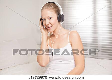 Young woman listening to music View Large Photo Image Stock Image - Young woman listening to music. Fotosearch