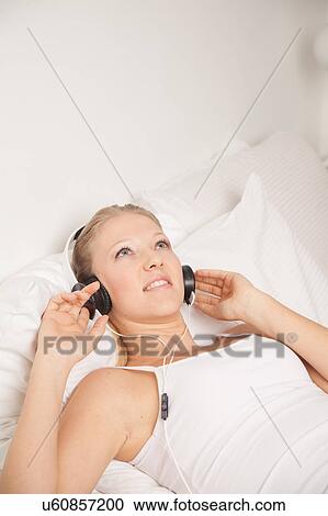Young woman listening to music View Large Photo Image Stock Image - Young woman listening to music. Fotosearch
