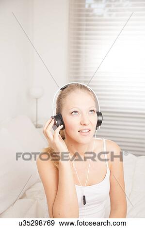 Young woman listening to music View Large Photo Image Stock Photo - Young woman listening to music. Fotosearch