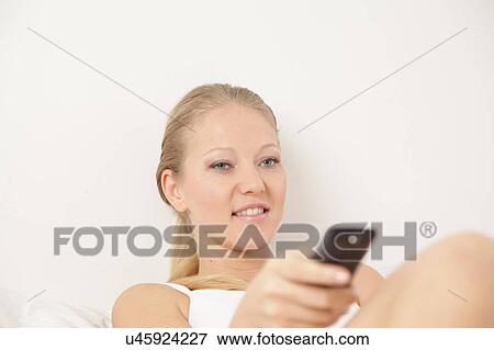 Young woman watching tv View Large Photo Image Stock Photo - Young woman watching tv. Fotosearch