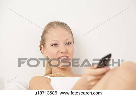 Young woman watching tv View Large Photo Image Stock Photograph - Young woman watching tv. Fotosearch