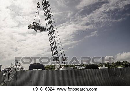 "Crash damaged car hanging from crane at breakers yard. Photographed in Teesside, UK" View Large Illustration Stock Illustration - "Crash damaged car hanging from crane at breakers yard. Photographed in Teesside, UK". Fotosearch