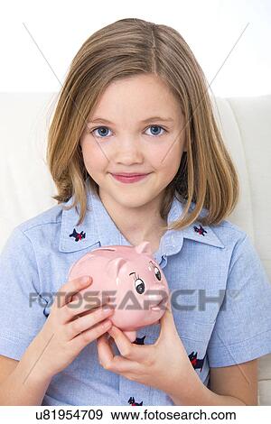 Stock Photo - Girl holding a piggy bank.. Fotosearch