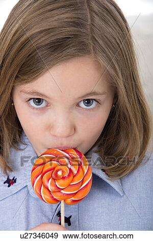 Girl licking a lollypop. View Large Photo Image Stock Photo - Girl licking a lollypop.. Fotosearch