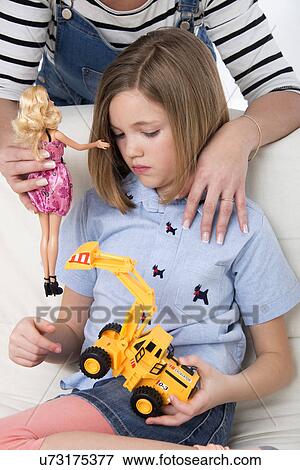 Girl playing with a toy truck and mother holding a doll. View Large Photo Image Stock Photo - Girl playing with a toy truck and mother holding a doll.. Fotosearch