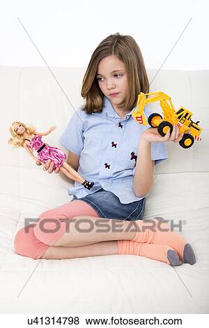 Stock Photo - Girl playing with doll and toy truck.. Fotosearch