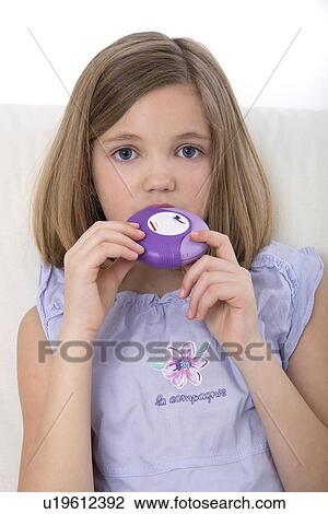 Stock Image - Girl using asthma medication.. Fotosearch