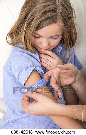 Person applying plaster to girl's arm. View Large Photo Image Stock Photo - Person applying plaster to girl's arm.. Fotosearch