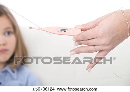 Person holding a digital thermometer with a girl in the background. View Large Photo Image Picture - Person holding a digital thermometer with a girl in the background.. Fotosearch