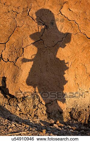 Stock Photograph - Himba shadow at sunset. Fotosearch