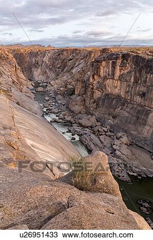Stock Image - Rocky river gorge at first light. Fotosearch