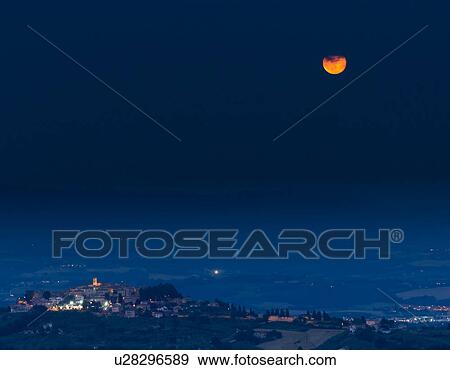 Stock Photo - Strawberry Full Moon rise over MonteCastello di Vibio, Umbria, Italy. Fotosearch