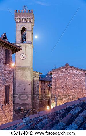 Stock Image - Umbrian medieval street of MonteCastello di Vibio, Italy with full moon setting over campanile. Fotosearch