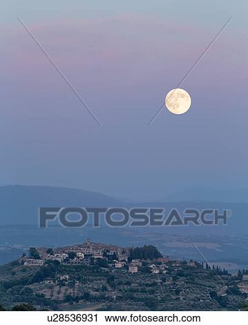 Stock Image - Umbrian medieval town of MonteCastello di Vibio, Italy at sunset with full moon rising. Fotosearch
