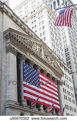 Stock Image - American flag on facade of New York Stock Exchange building. Fotosearch