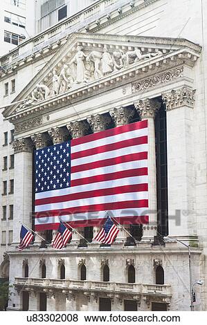 Stock Photo - American flag on facade of New York Stock Exchange building. Fotosearch