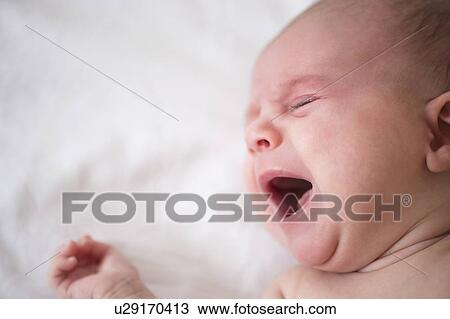 Stock Image - Baby girl (2-5 months) crying in crib. Fotosearch