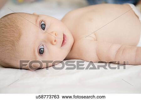 Baby girl (2-5 months) lying on bed View Large Photo Image Stock Image - Baby girl (2-5 months) lying on bed. Fotosearch