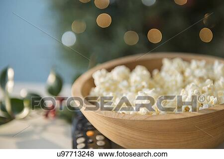 Stock Photo - Bowl of popcorn with Christmas decorations in background. Fotosearch