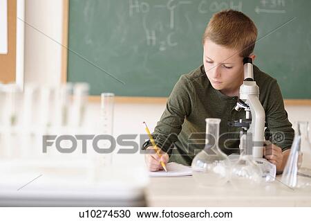 Boy (8-9) taking notes in classroom View Large Photo Image Stock Image - Boy (8-9) taking notes in classroom. Fotosearch