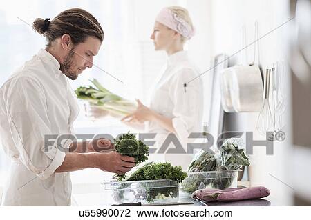 Stock Image - Chefs working in kitchen. Fotosearch