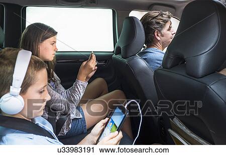 Children (8-9, 10-11) texting in back seat View Large Photo Image Stock Image - Children (8-9, 10-11) texting in back seat. Fotosearch