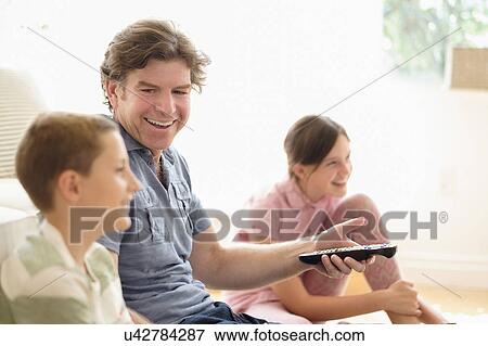 Children (8-9, 10-11) watching TV with their father View Large Photo Image Stock Photo - Children (8-9, 10-11) watching TV with their father. Fotosearch