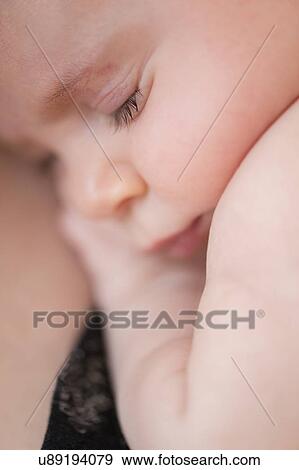 Stock Photo - Close-up of baby girl (2-5 months) hugging her mother. Fotosearch