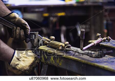 Close-up of man working in metal workshop View Large Photo Image Stock Photo - Close-up of man working in metal workshop. Fotosearch