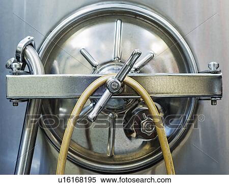 Stock Photography - Close up of stainless steel tank in winery cellar. Fotosearch
