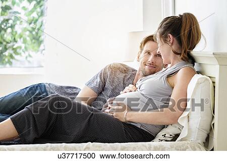 Stock Image - Couple lying in bed. Fotosearch