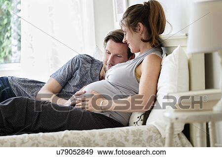 Stock Photo - Couple lying in bed. Fotosearch
