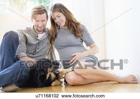 Couple relaxing with dog on floor View Large Photo Image Stock Image - Couple relaxing with dog on floor. Fotosearch