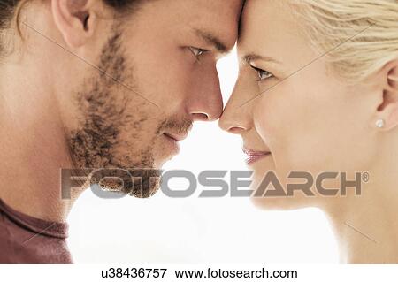 Stock Photo - Couple rubbing noses on white background. Fotosearch